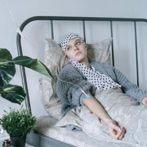 Woman in Gray and White Hijab Sitting on White Bed