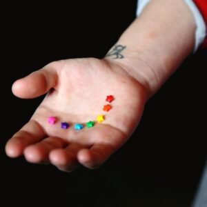 Yellow Pink and Blue Flower Petals on Persons Hand